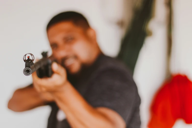 a man holding a gun aiming at the viewer