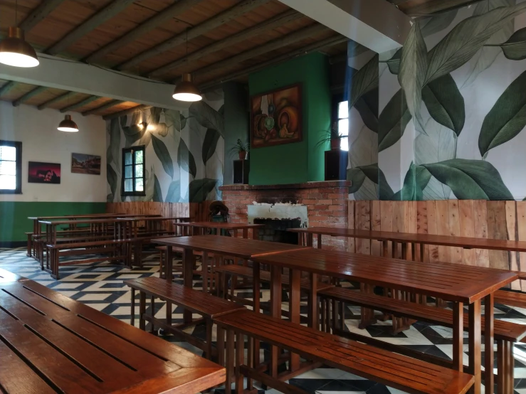 a row of wooden benches next to some large windows