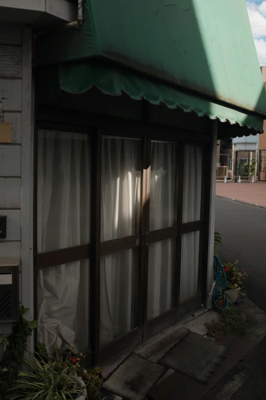 the window of the building has been covered with a green tarp