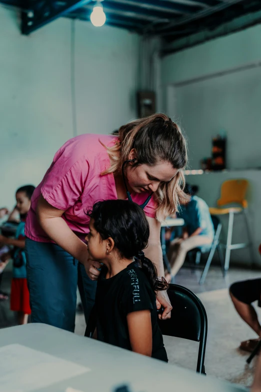 an image of a woman helping a child to use a computer