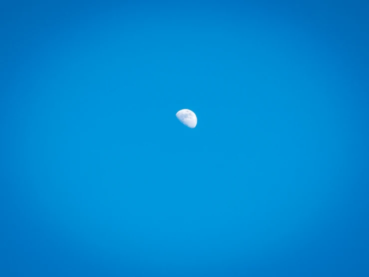 a picture of the moon in the sky on a bright day