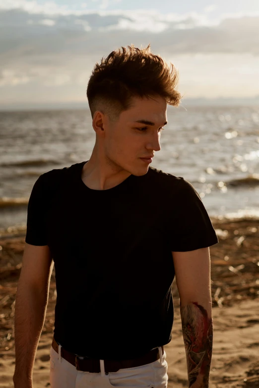 a man standing on a beach with a black shirt on