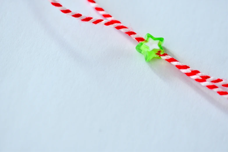 an empty red and white striped straw with a green star on it