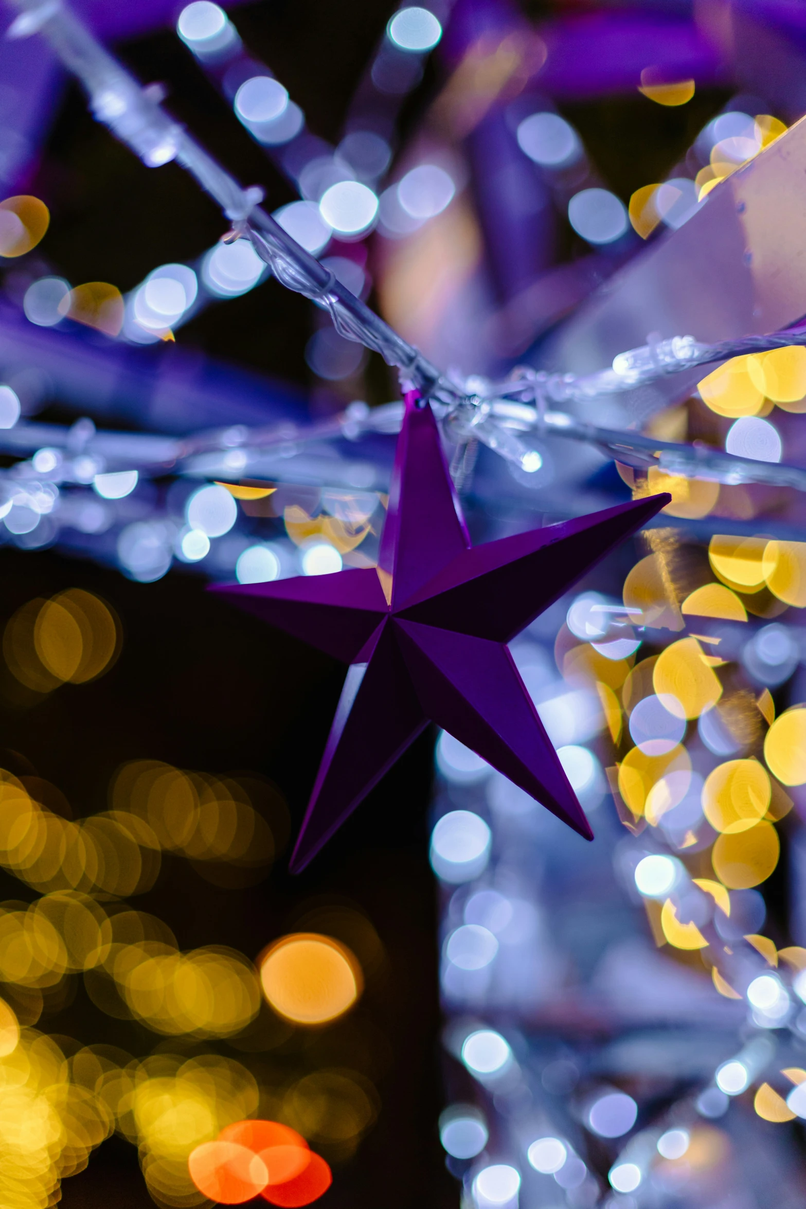 a purple star hanging from the side of a glass ornament