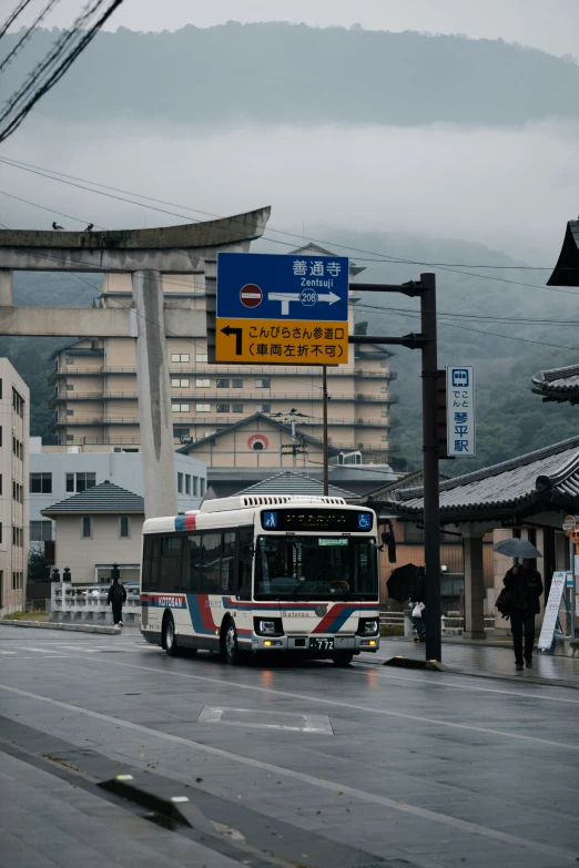 a city bus on the road in the middle of town