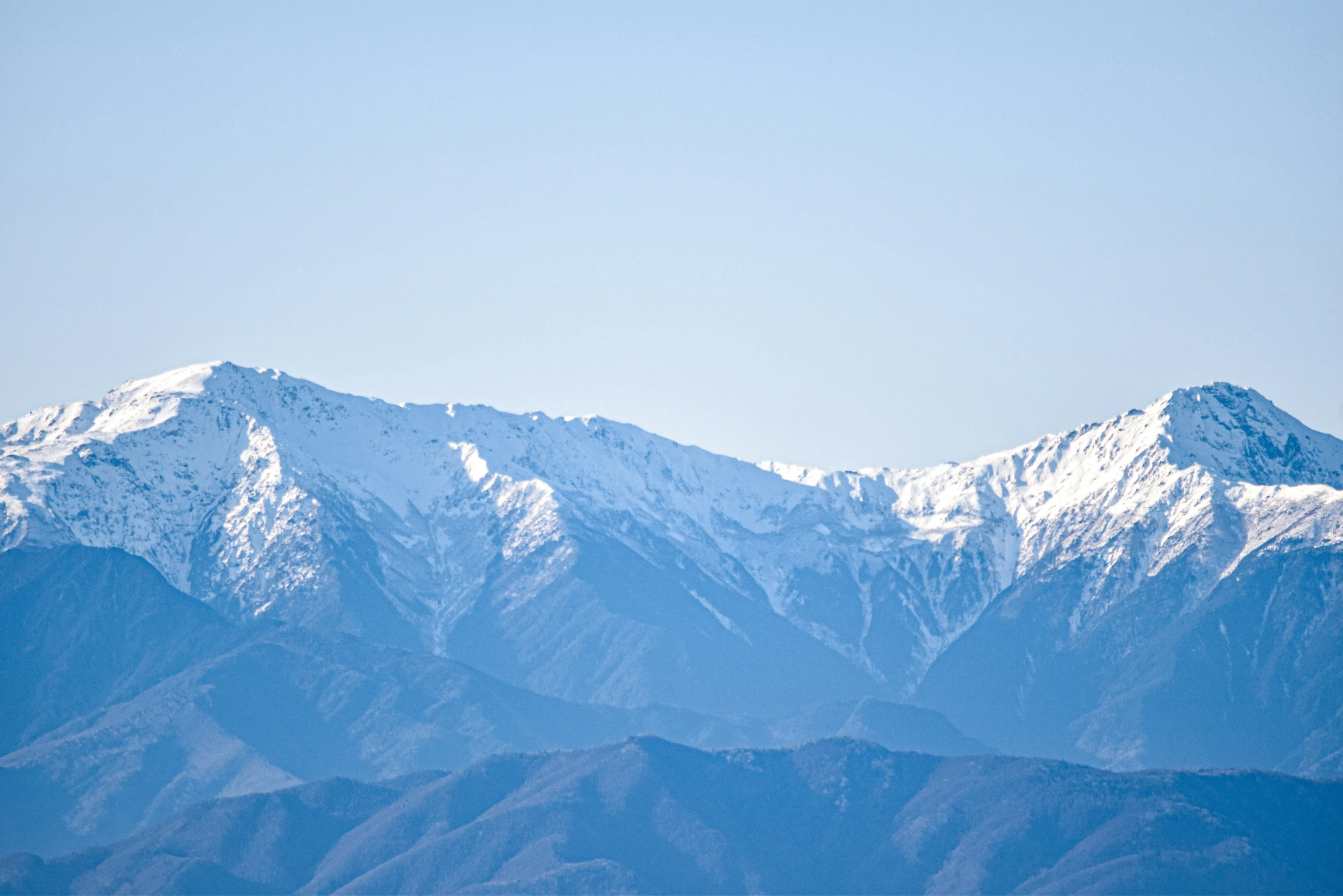 some white mountains in the distance as seen from a plane