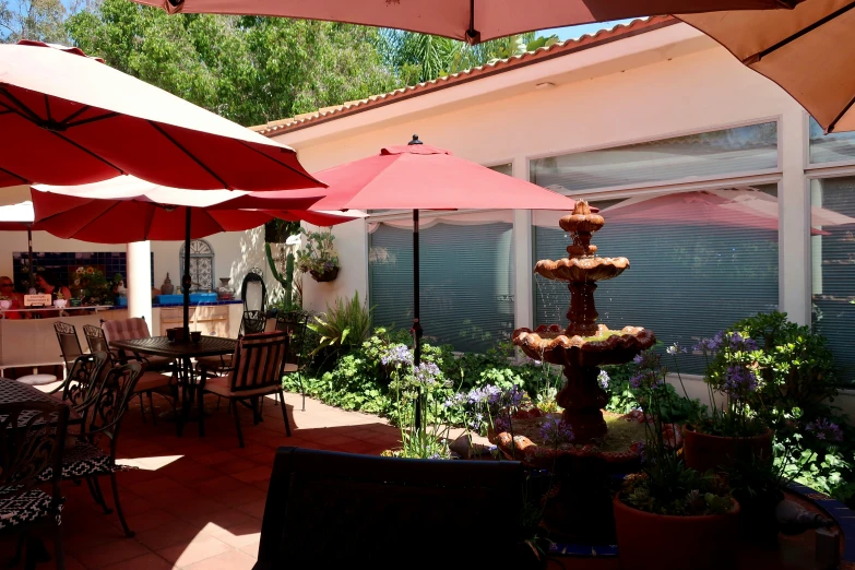 a patio with an outdoor table and umbrellas