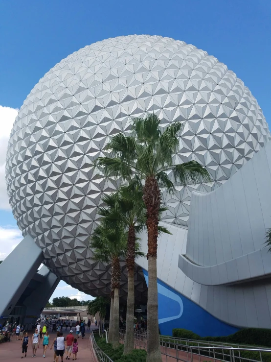 a big ball building with people walking outside