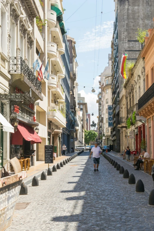 an empty street with people walking on the sidewalk