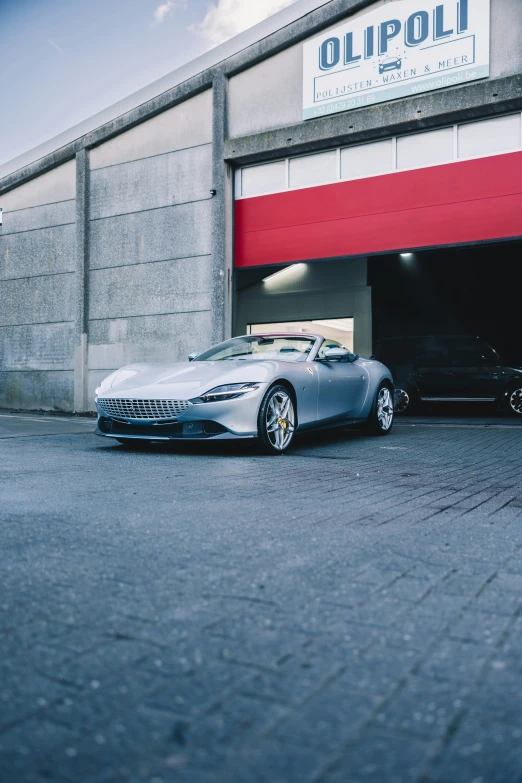 a car in front of a large garage that has a roof and is painted blue