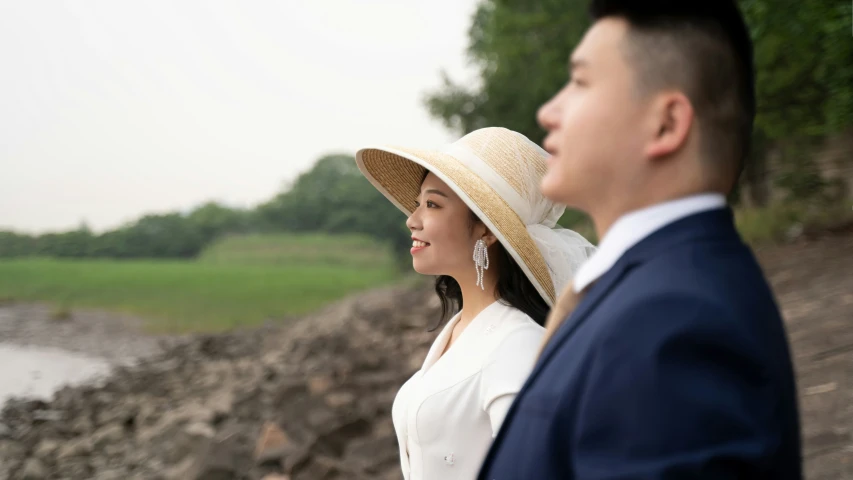 a woman wearing a hat is standing next to a man