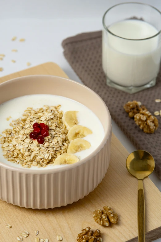 banana oatmeal and fruit in a dish next to a glass of milk