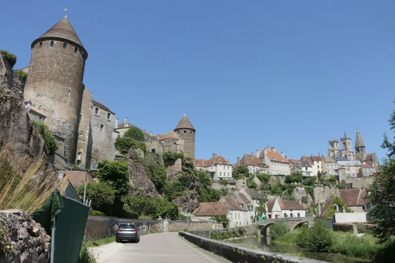 a car driving down a road in front of an old castle