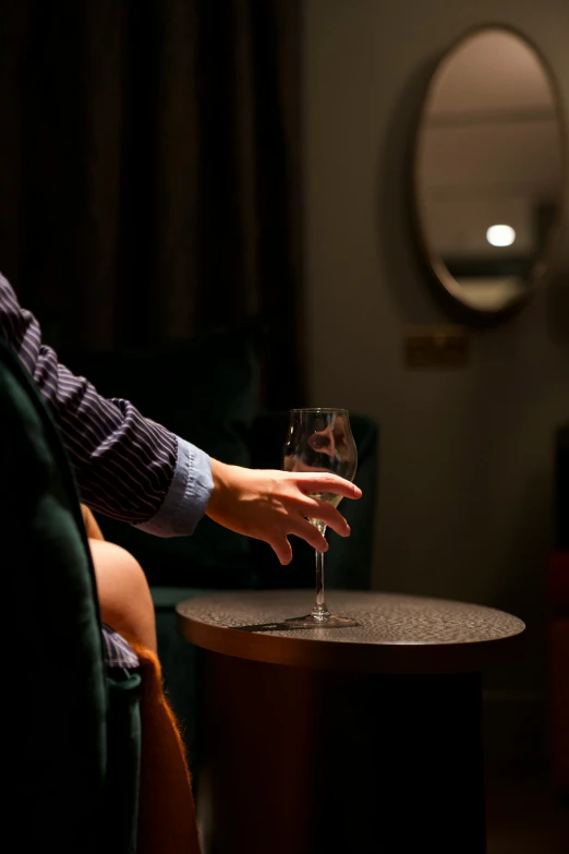 a glass of wine being toasted by someone in a room