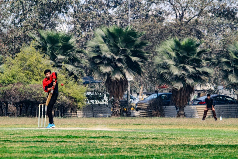 a  is swinging his bat at a ball in the field