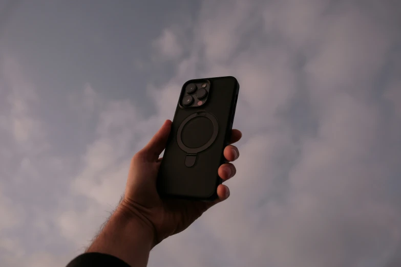 a person holding their cellphone with a blue sky in the background