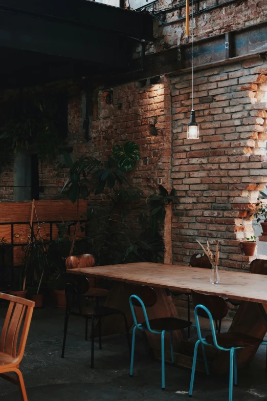 a wooden table sitting next to an old brick wall