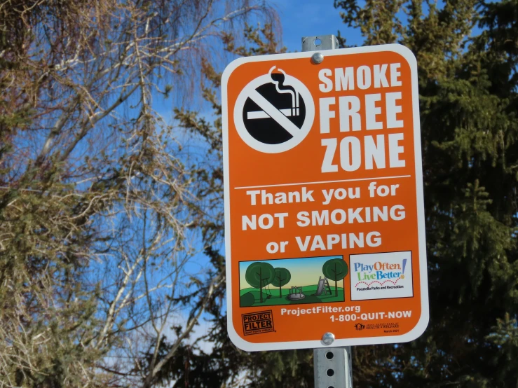 a no smoking sign is shown in front of trees