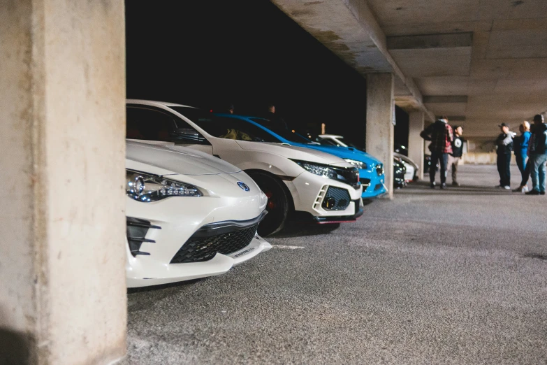 some very pretty colorful sports cars parked in a parking lot