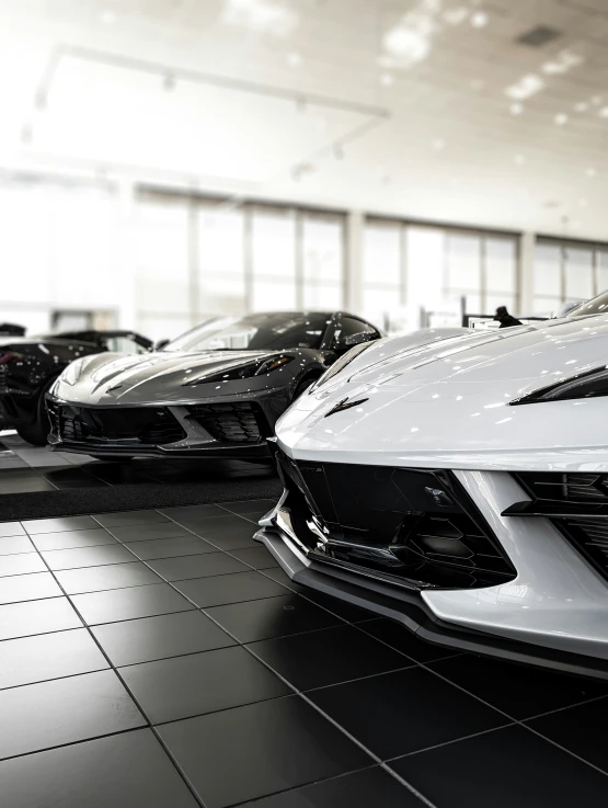 some very fancy looking cars sitting in a big room