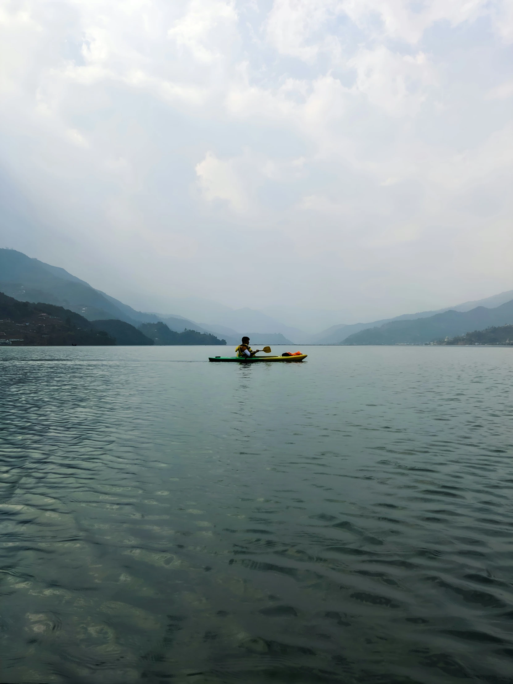 a man is in a canoe with mountains on the background