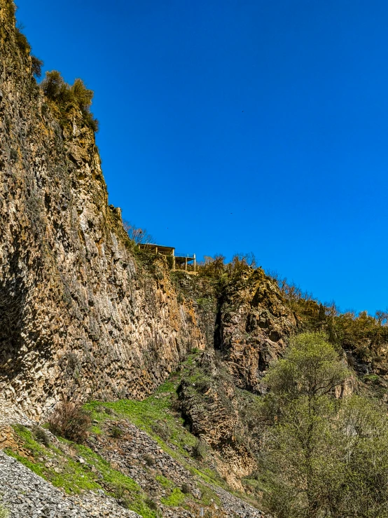 a mountain covered in vegetation and rocks on the side of a hill