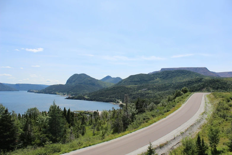 a winding road leads to a lake in the distance