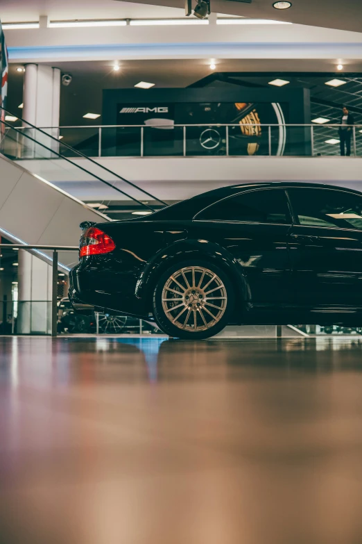 a black car sitting on top of a wooden floor