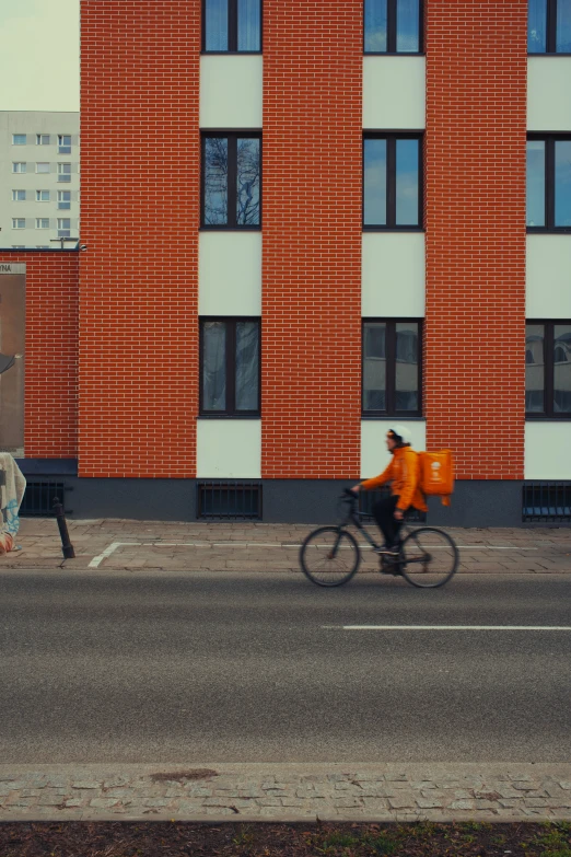 a bike rider passes another bicyclist past a tall building