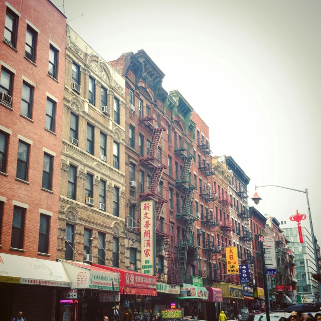 people walk through a crowded city street lined with buildings