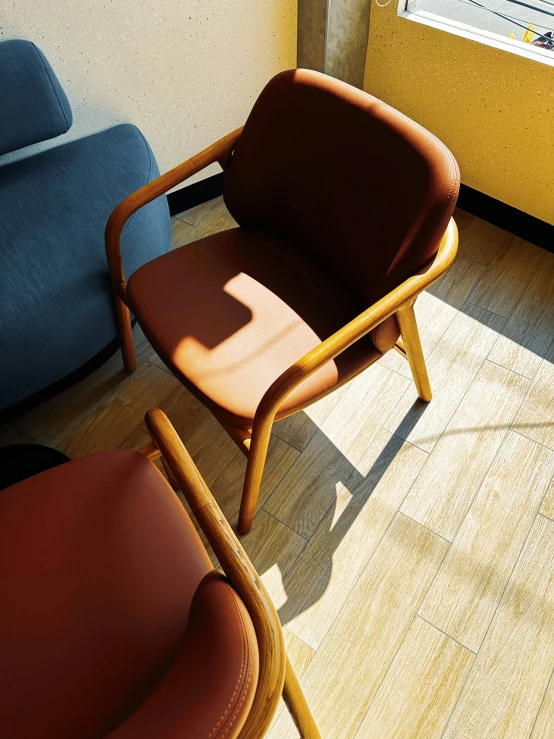 two leather chairs sitting on a hard wood floor