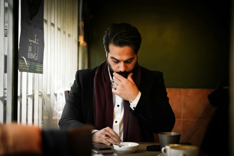 a man that is sitting down looking at a plate of food