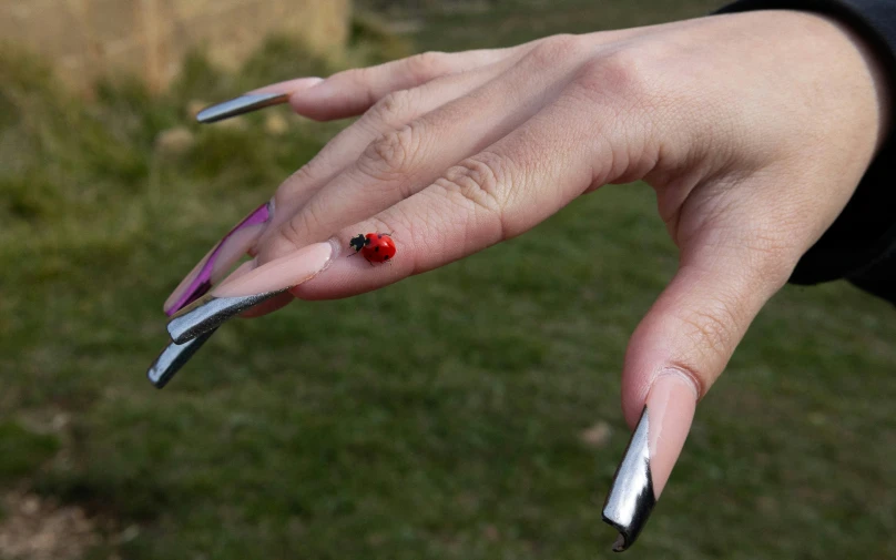 a female hand with chrome and red nail polish