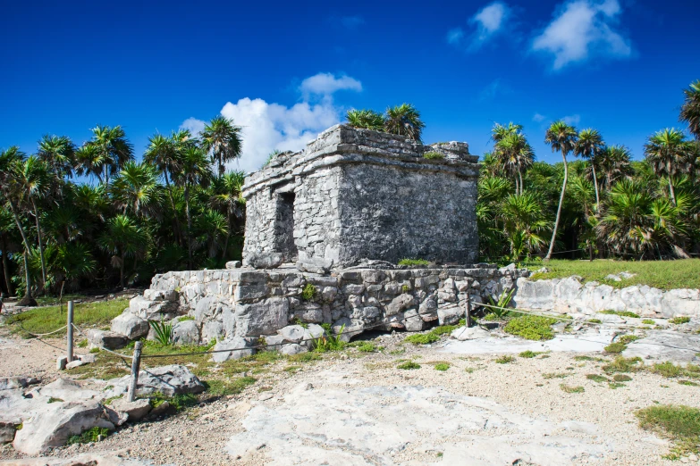 a small stone structure surrounded by trees and rocks