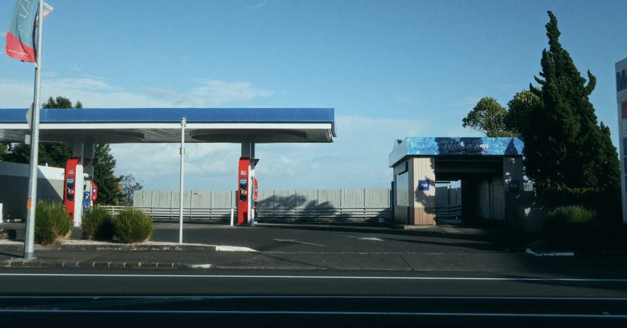 the gas pump sits beside a street with flags