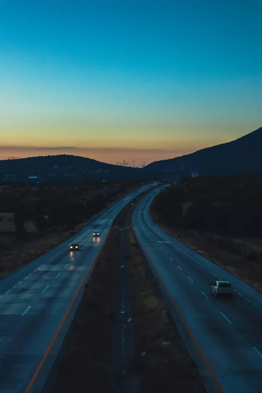 an interstate with traffic travelling at dusk on a highway