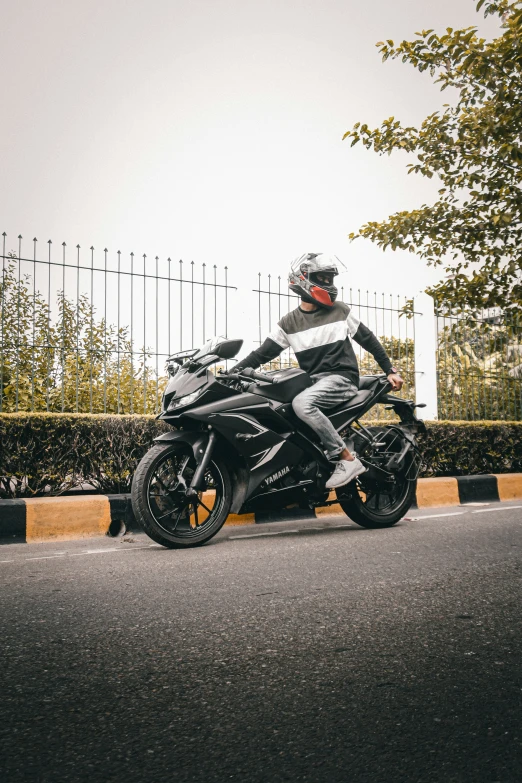 the man is wearing all black and riding on his motorcycle