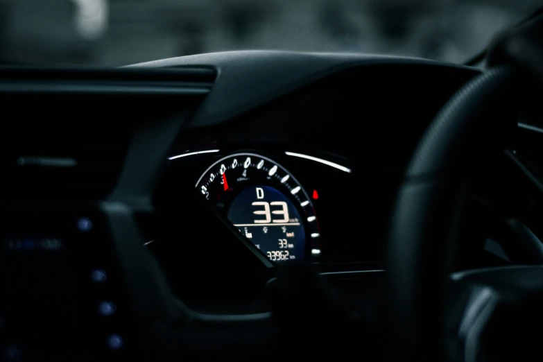 an analog dashboard on a car in the dark