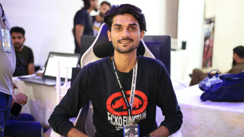 man smiling and wearing black shirt at desk