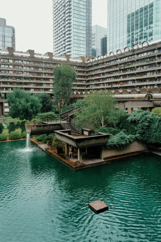 people on a bench in front of a building and pond