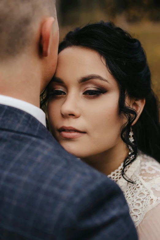 the bride in an embellished dress and groom are staring into the distance