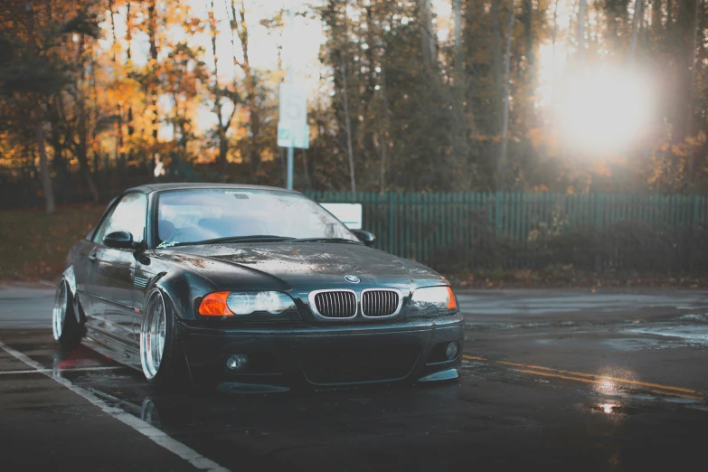 a bmw parked in the rain in a parking lot