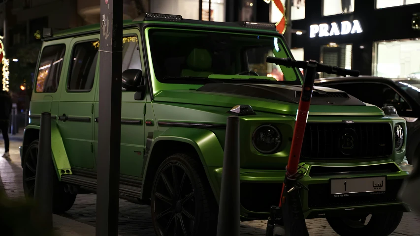 a green jeep is parked on a street