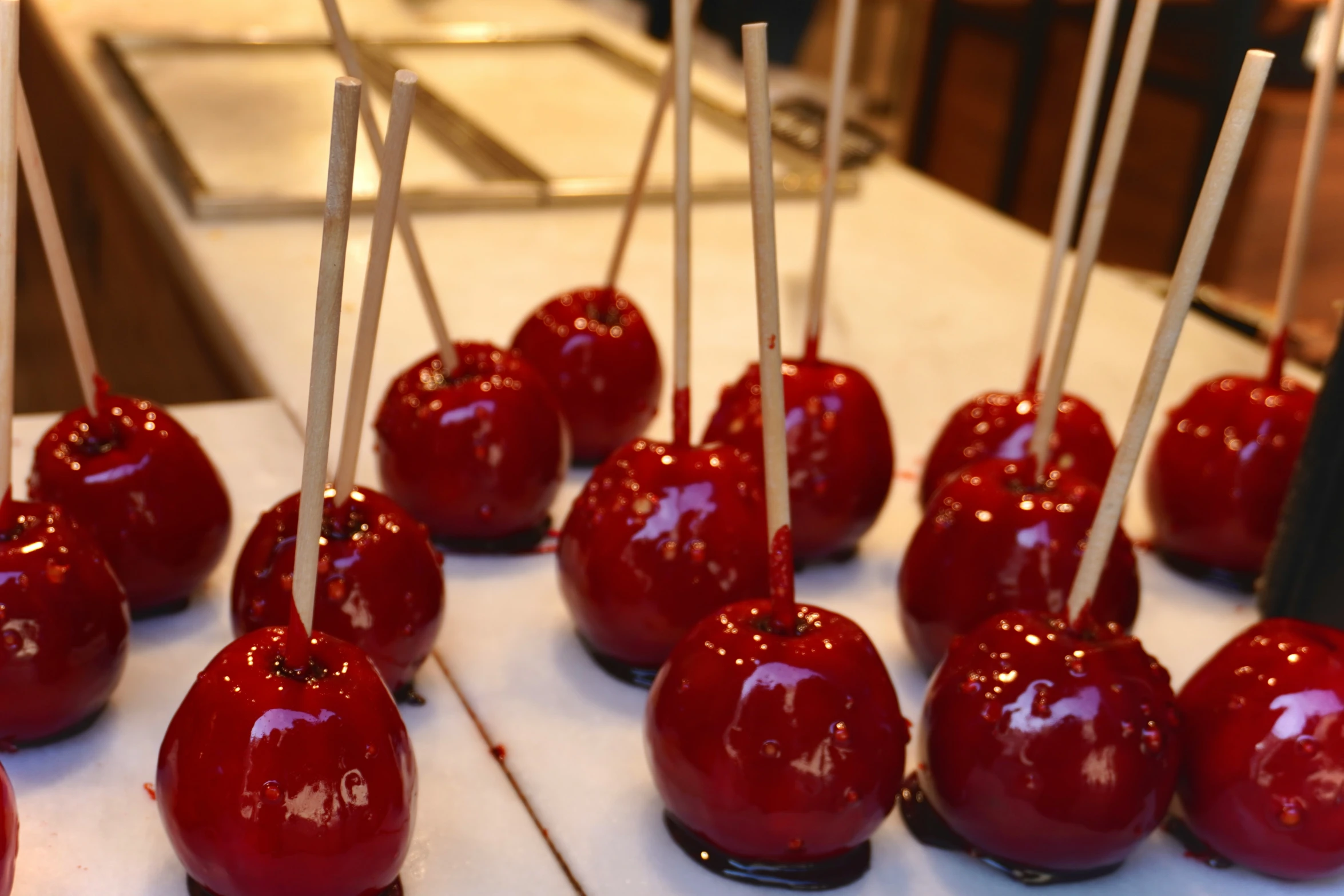 several candy apples sit on sticks with nozzles