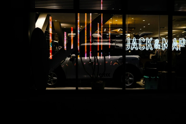 a dark room containing the outside window of a car dealership