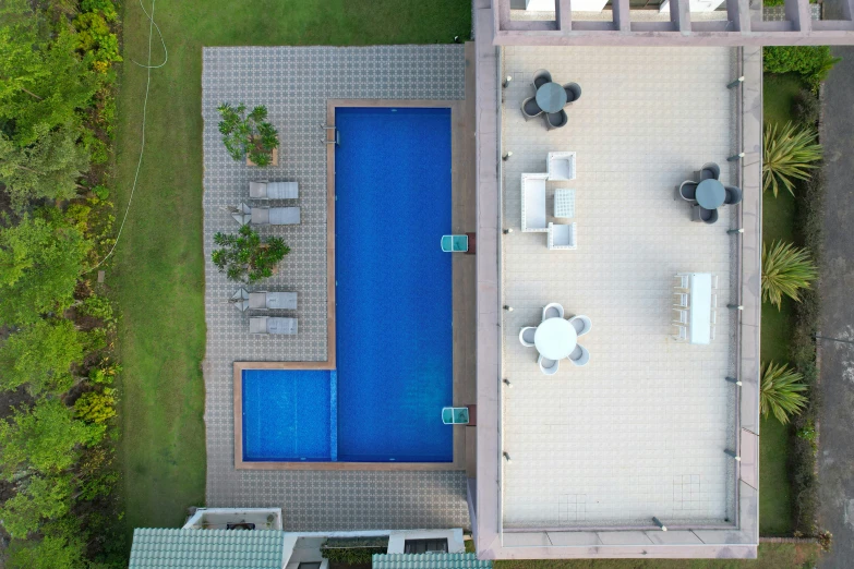 a pool next to a lawn and patio furniture