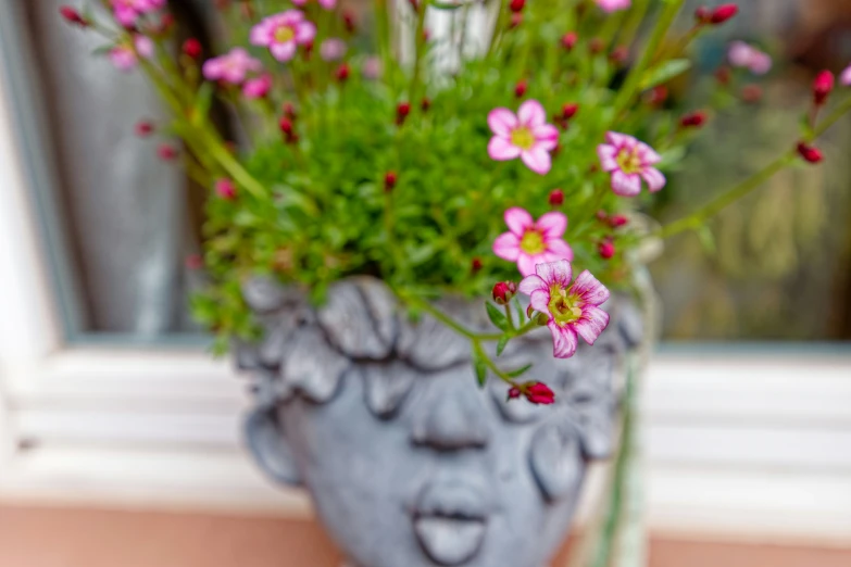 an unusual vase with a face made out of clay