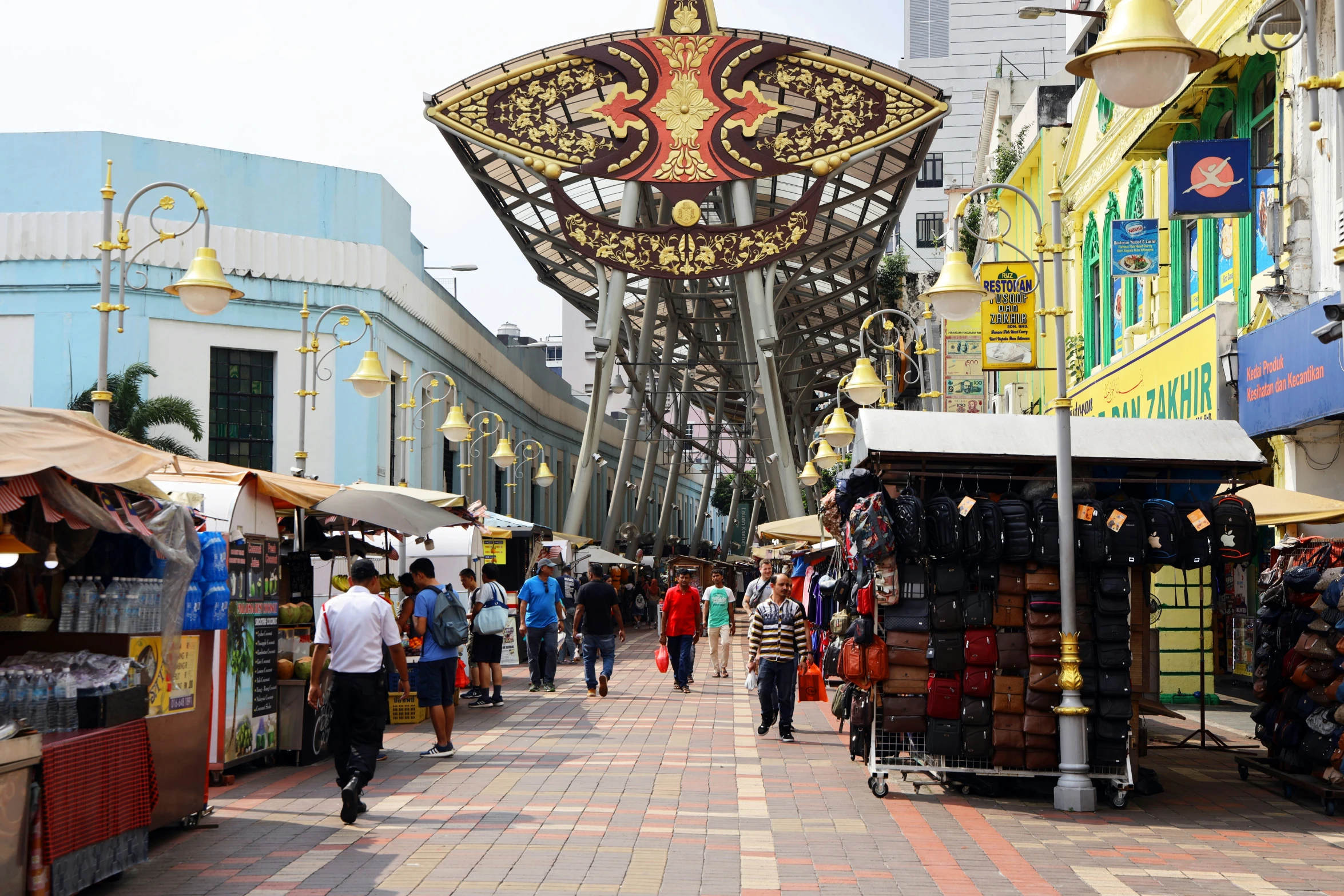 people are shopping on the busy street with umbrellas