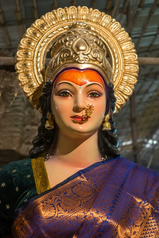 the head and forehead of an indian woman wearing golden jewelry