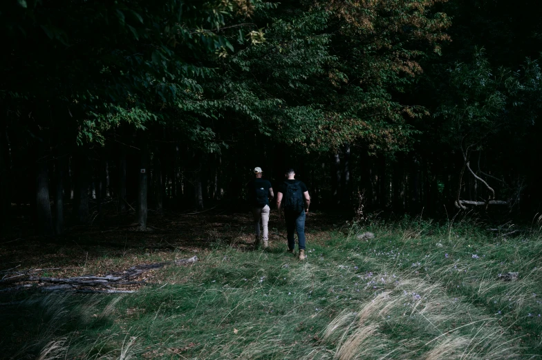 two people stand together near trees in the dark